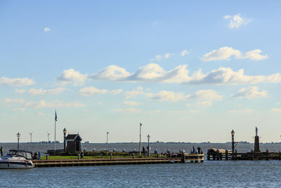 Scenic view of river by buildings against sky