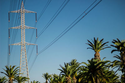 Low angle view of palm trees against clear blue sky