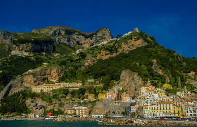 Buildings by sea against sky