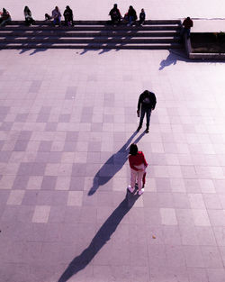 People walking seen from a high angle view. hard shadows casting.