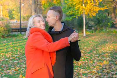 Couple kissing in park during autumn