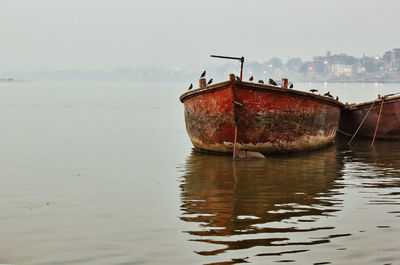 Fishing boat in sea against sky