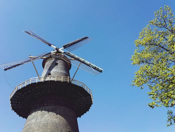 Low angle view of traditional windmill against clear sky