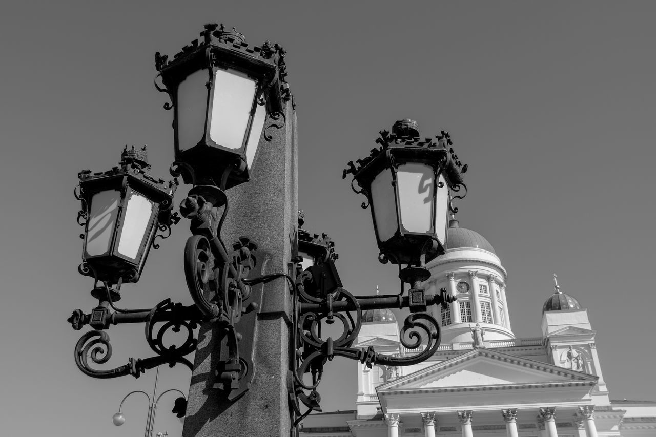 black and white, lighting equipment, architecture, low angle view, street light, monochrome photography, monochrome, built structure, sky, building exterior, white, light fixture, no people, clear sky, black, history, nature, the past, building, lighting, outdoors