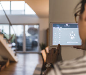 Woman using screen with smart home control functions at home