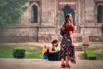 Full length of woman sitting outdoors