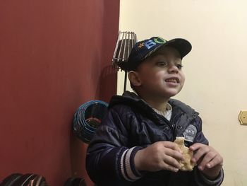 Portrait of boy looking away against wall
