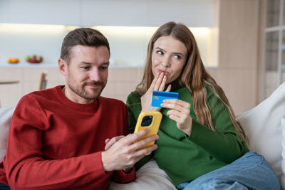 Addicted to online shopping wife and husband spend money in online shop, pay by e-wallet application