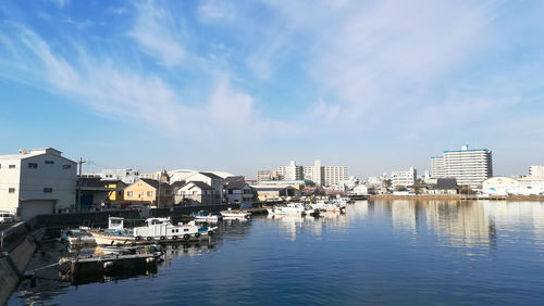 Boats moored in bay against buildings in city