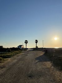 Scenic view of road against clear sky during sunset