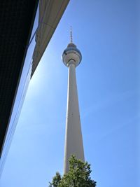 Low angle view of communications tower against blue sky