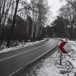 Road passing through forest in winter