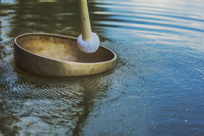 Resonating tibetan singing bowl is floating on water 