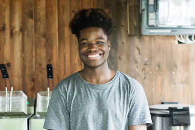 Portrait of young man standing against wall