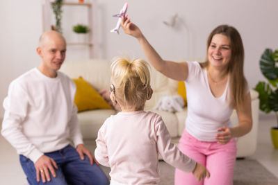 Portrait of happy family standing against wall