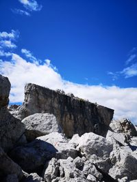 Low angle view of rocks against blue sky