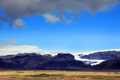 Scenic view of snowcapped mountains against blue sky