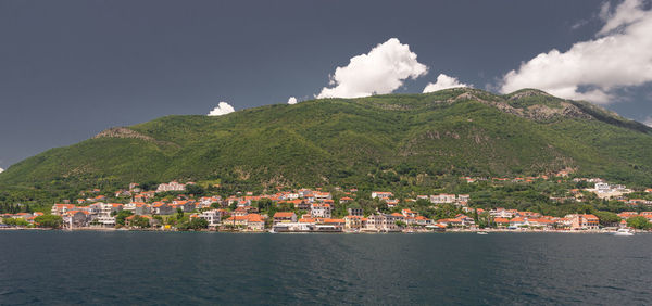 Scenic view of townscape by sea against sky