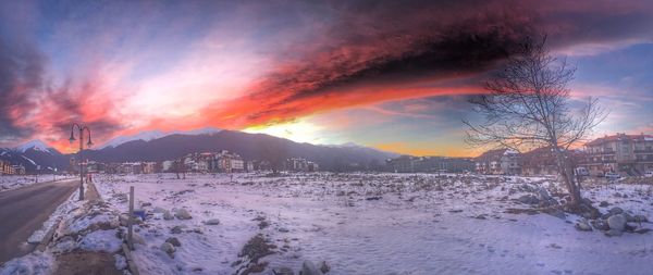 Scenic view of mountains against cloudy sky at sunset