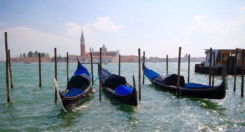 Boats moored on wooden post in water