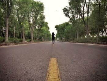 Rear view of woman walking on road