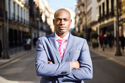 Portrait of businessman standing on road in city