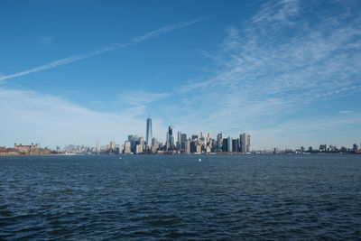 Sea and cityscape against sky