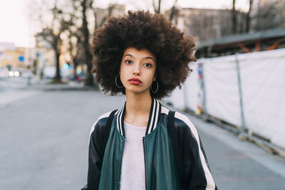 Portrait of young woman standing on bridge