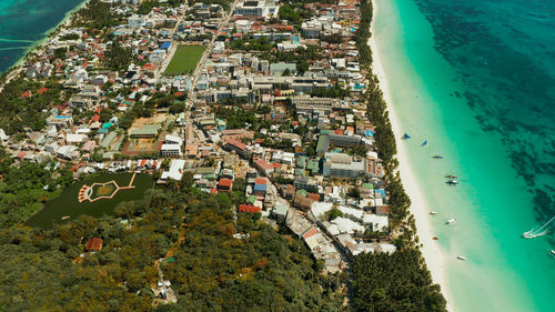 Tropical lagoon with turquoise water, sailing yachts and white sand beach from above. boracay