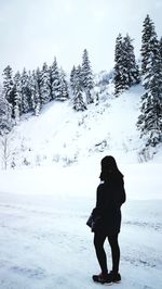 Full length of woman standing on snow covered field