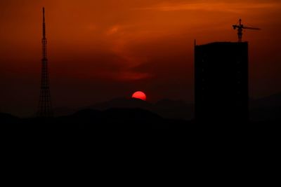 Silhouette tower against orange sky during sunset