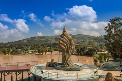 Statue of buddha against cloudy sky