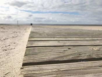 Close-up of wooden posts on beach against sky