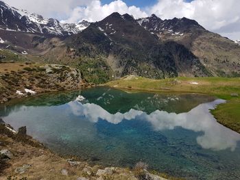 Scenic view of lake by mountains against sky