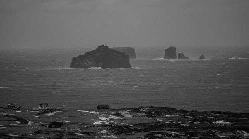 Rocks on sea shore against sky