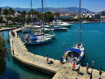 Boats moored at harbor against sky