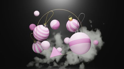 Close-up of pink balloons hanging against black background