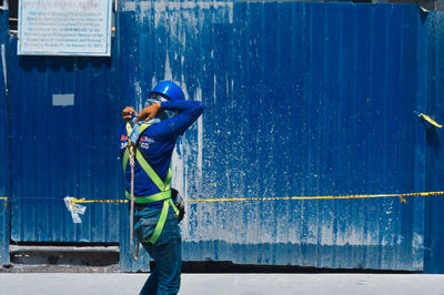 Man working on blue wall