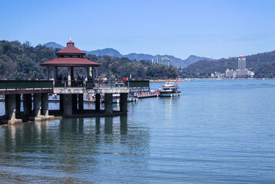 Pier with gazebo in lake against sky