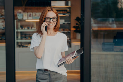 Young woman wearing sunglasses while standing in cafe