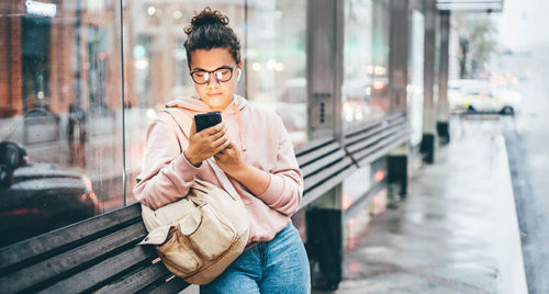 Young man using mobile phone in city