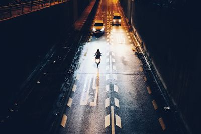High angle view of man walking on road at night