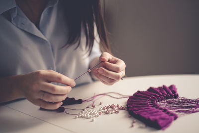 Woman working with threads and beads close-up, concept creativity, handicraft, hobby, toning