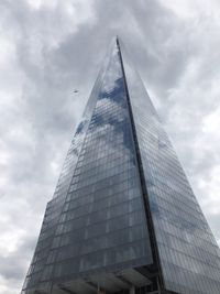 Low angle view of skyscraper against cloudy sky