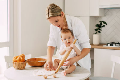 Woman preparing food with child in kitchen