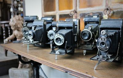 Close-up of antique cameras on wooden table