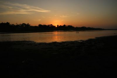 Scenic view of lake against orange sky
