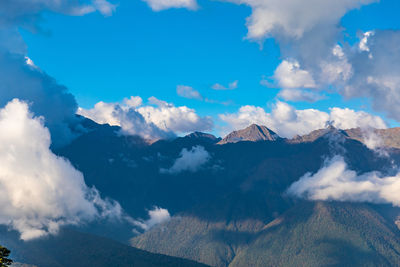 Aerial view of snowcapped mountains against cloudy sky