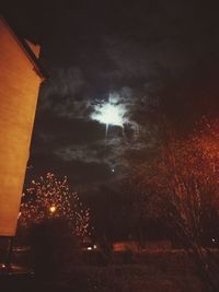 Low angle view of illuminated trees against sky at night