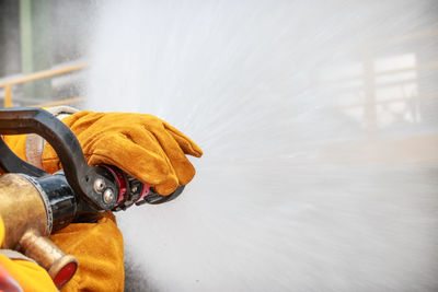 Cropped image of firefighters spraying water